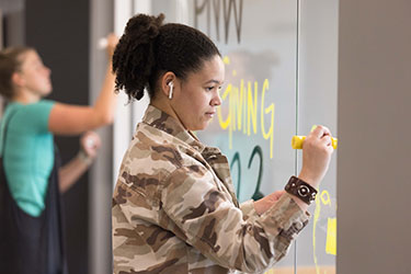 A PNW student uses window markets to paint a window