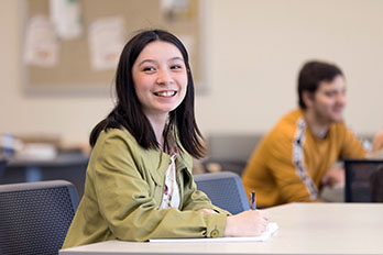 A PNW student takes notes in the classroom