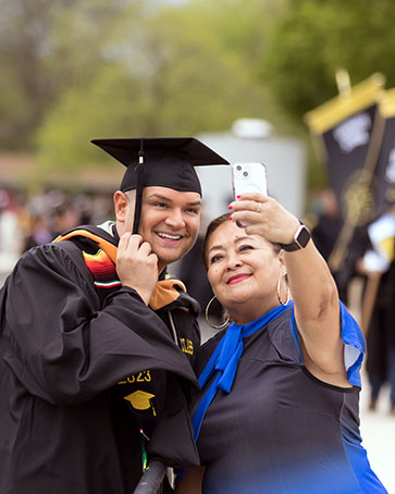 A PNW student poses for a selfie with his mom at Commencement