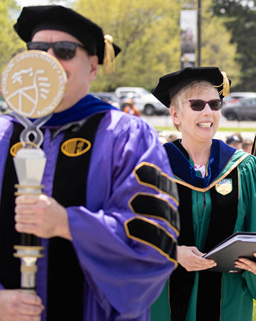 PNW faculty members march in at Commencement, one carrying the PNW mace.