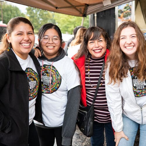 Four people pose together during a Hispanic Heritage Month Festival