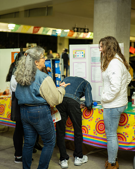 Two people talk at a booth during a Hispanic Heritage Month Festival