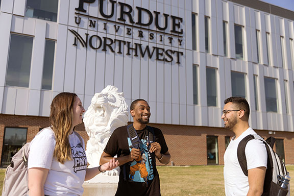 PNW students talk near a lion sculpture in front of the Nils K. Nelson Bioscience Innovation Building