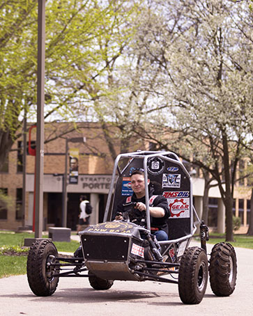 A PNW student drives a dune buggy on campus