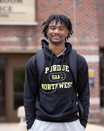 A PNW student stands outdoors in a Purdue Northwest hoodie.