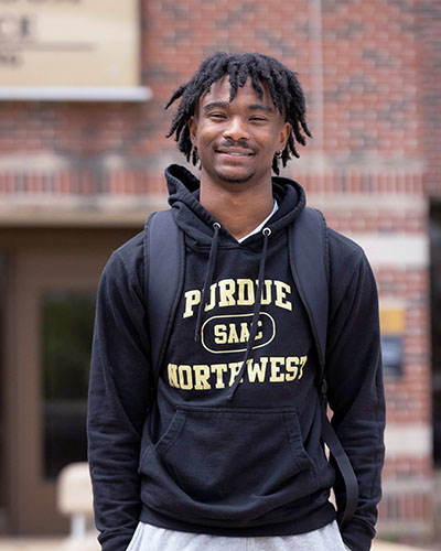 A PNW student stands outdoors in a Purdue Northwest hoodie.