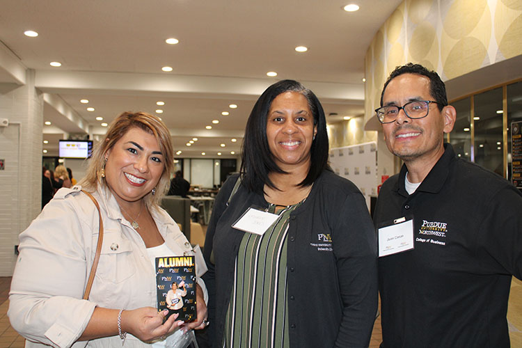 Three people with name tags pose together