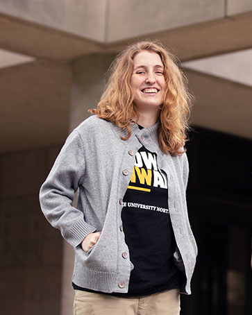 A female PNW student in a Power Onward t-shirt and a sweater.