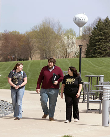 Students walk on PNW's Westville branch campus, with a water tower in the background.