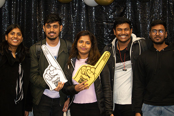 Five students pose together with first-gen pride foam fingers