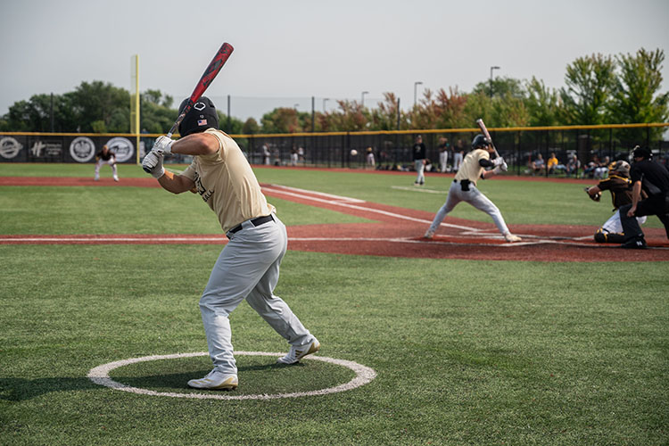 PNW Baseball players - one is at bat and the other is warming up