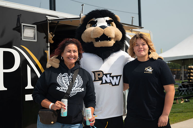 Two people pose with Leo the Lion