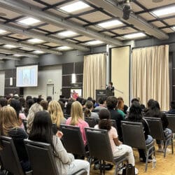 People sit in rows of chairs for a lecture