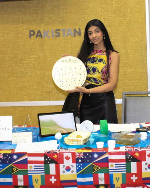 A student stands at a Pakistan table during Global Groove