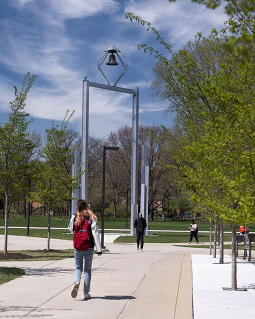 A PNW student walks in front of the Bell Tower