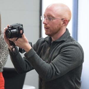 A PNW staff member looks through a camera.