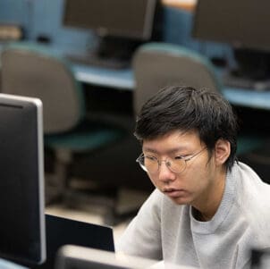 A student sits at a desktop computer