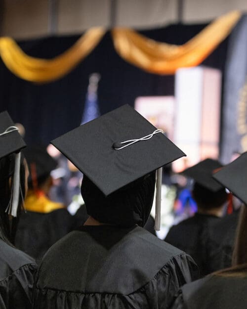 PNW graduates during a commencement ceremony. The graduates are pictured from the back