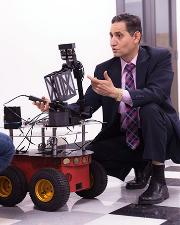 A PNW scientist works with a wheeled robot.