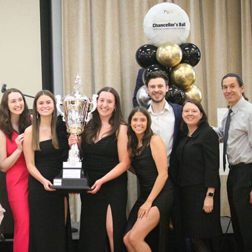 A student organization stands with their faculty advisors after winning an award at the Chancellor's Ball.