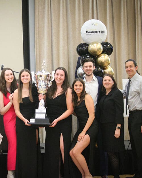 A student organization stands with their faculty advisors after winning an award at the Chancellor's Ball.