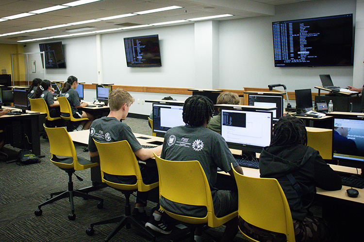 GenCyber camp participants looking at a code on the computer screen