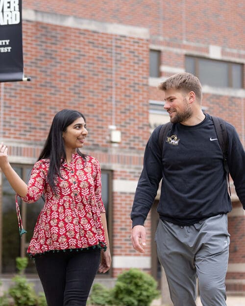 Two students walk together outside.